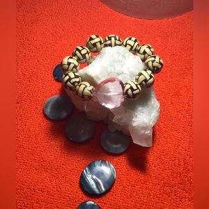 A homemade one size fits all elastic band tan and black pink heart